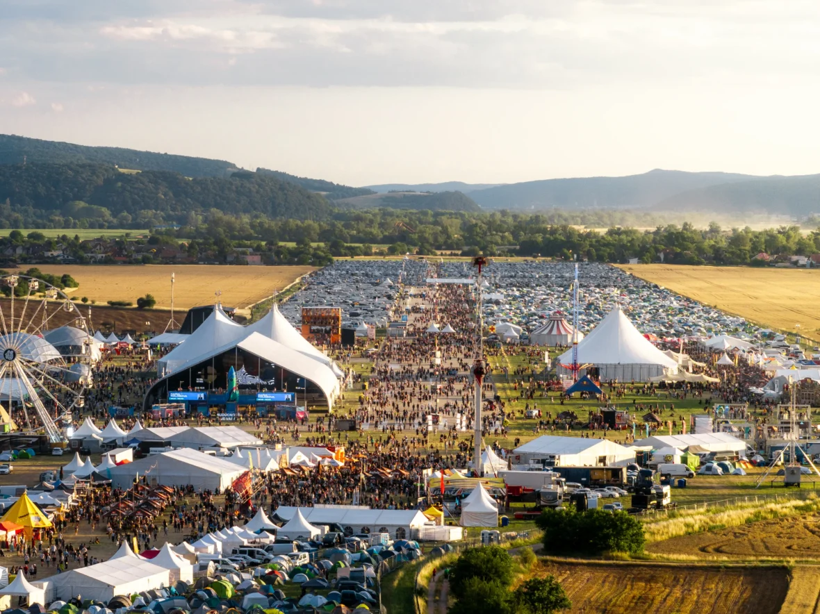 Widok z drona na teren festiwalu, białe namioty ze scenami i pole namiotowe dla uczestników
